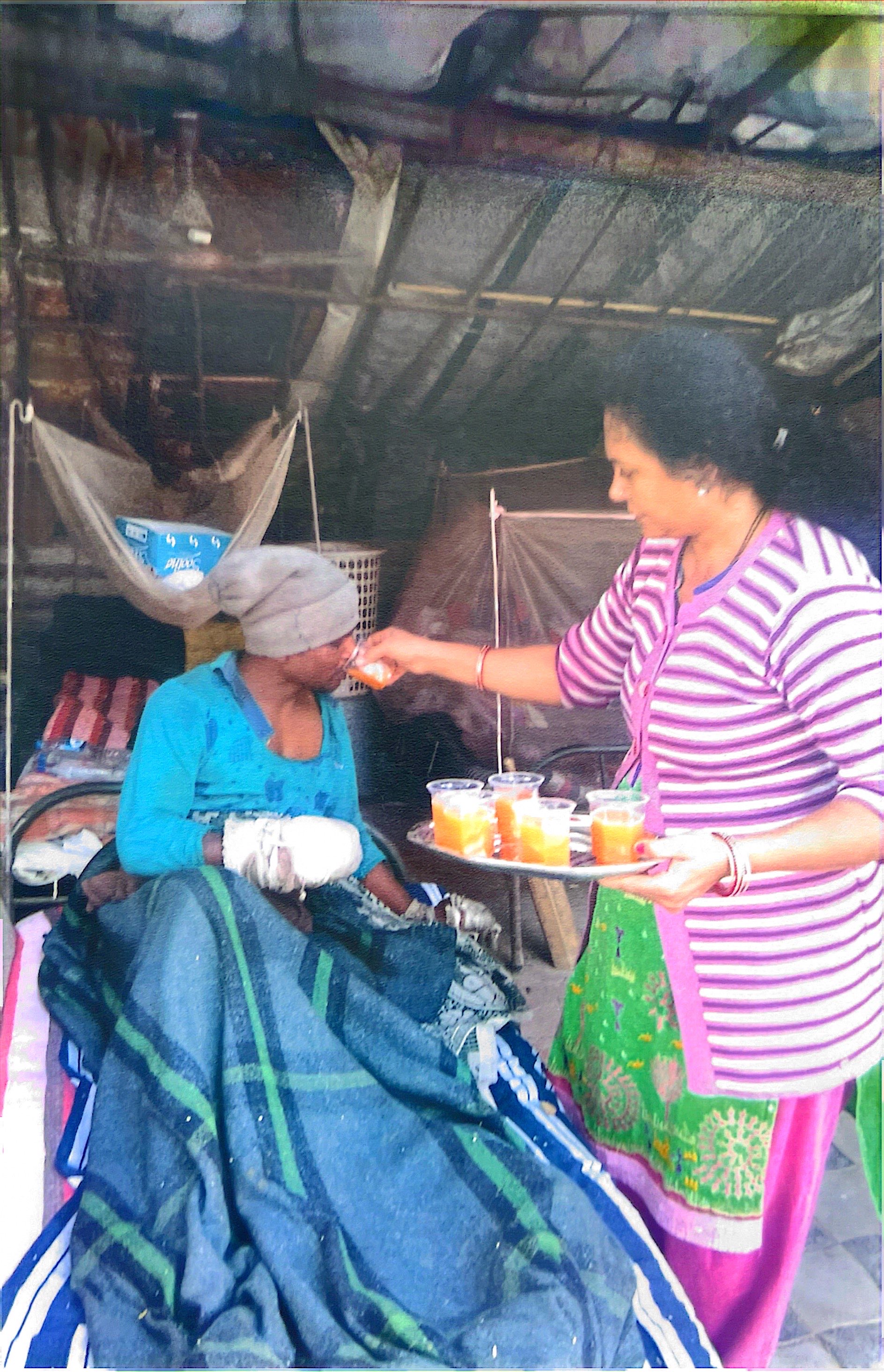 Volunteer feeding elderly patient with compassionate care